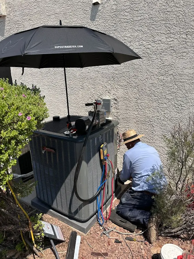 HVAC technician performing outdoor AC maintenance in Waikoloa Village