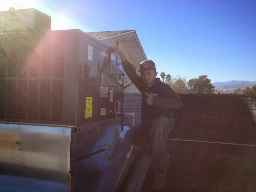 HVAC technician performing AC Tune-Up on a rooftop unit in Waikoloa Village